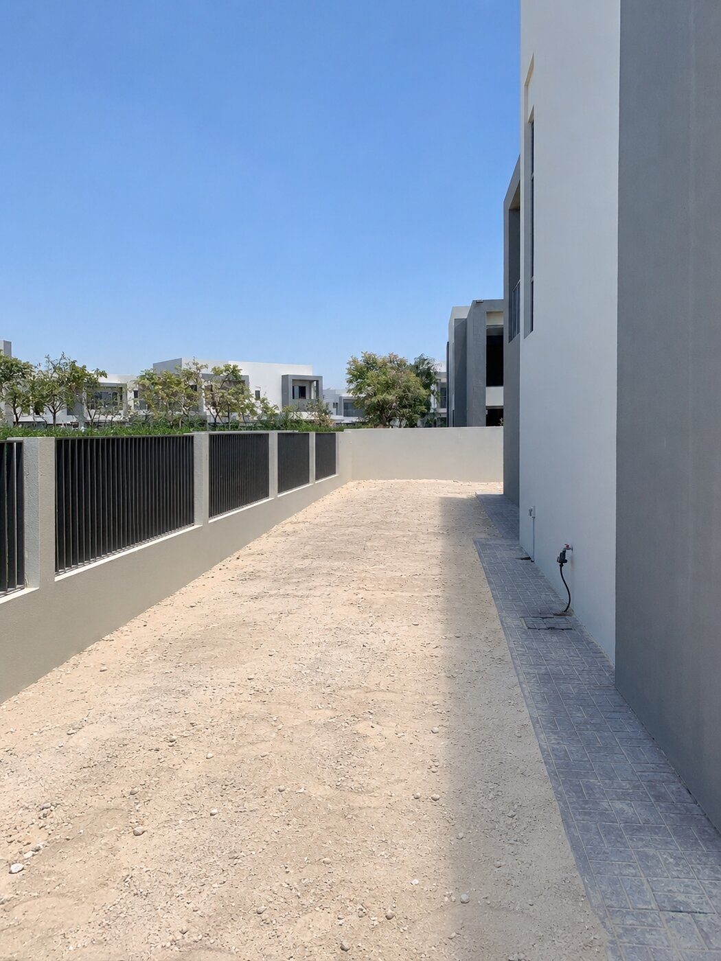 Dubai Hills Estate villa side garden before landscaping — bare sand side passage