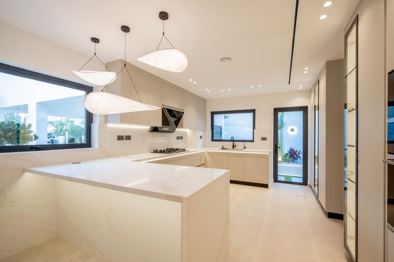 The Meadows villa kitchen after renovation — open-plan layout with island and bespoke cabinetry