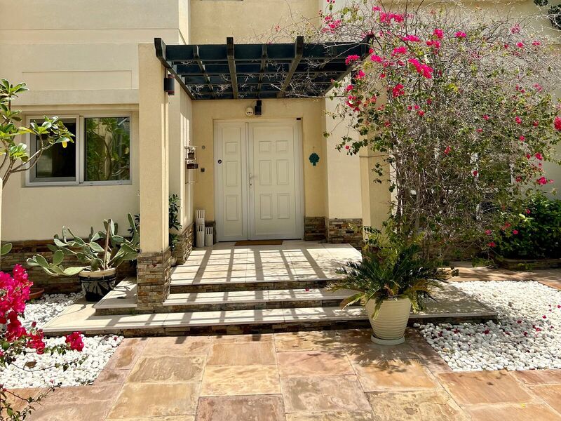 The Meadows villa front entrance before renovation — original façade and dated pergola